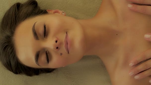Vista dall'alto piacevole viso con gli occhi chiusi del cliente donna al salone di bellezza spa sdraiato sul divano — Video Stock