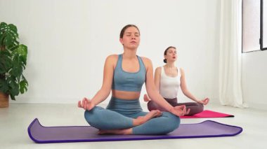 İki kadın meditasyon ve yoga yaparken huzurlu bir an yakaladık. Huzuru ve odaklanmayı somutlaştırırken aynı zamanda iç huzuru ve farkındalığı teşvik ediyorlardı..