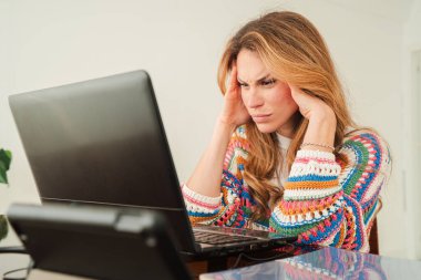 Hüsrana uğramış bir kadın evinde dizüstü bilgisayarı üzerinde çalışırken yoğun stres ve tükenme yaşıyor. Parlak ve açık bir odada duygusal mücadelesini sergiliyor..