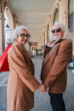 Neşeli bir son sınıf çifti el ele tutuşurken, sevgi ve arkadaşlığı paylaşırken, keyifli bir alışveriş deneyimi yaşarken, sıcaklığı ve mutluluğu birlikte paylaşırken yakalanan yürek ısıtan bir an.