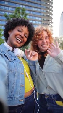 Neşeli bir selfie için birbirlerine poz verirken eğlenen iki mutlu kız, kahkaha ve arkadaşlıkla dolu neşeli bir anı yakalıyorlar, birlikte kalıcı anılar yaratıyorlar..