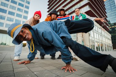 An energetic breakdancer showcases an impressive freeze move, captivating fellow dancers and onlookers with their incredible skills and enthusiasm for the art of dance, creating a vibrant atmosphere