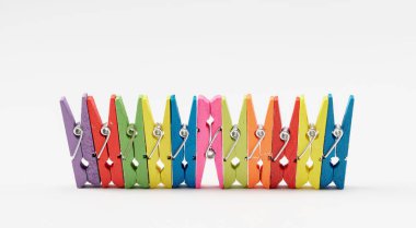 Renkli ahşap mandallar beyaz arka planda dizilmiş, yakın plan..