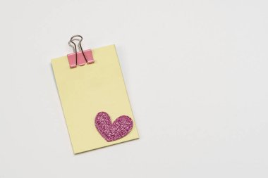 Kalpli yapışkan sarı kâğıt notlar. Beyaz bir arka planda. Sevgililer Günü