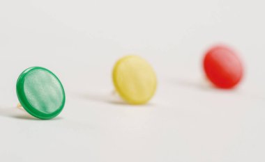 Beyaz arka planda renkli ofis broşları koleksiyonu. Sıkıcı çalışma günlerinde parlak renkler