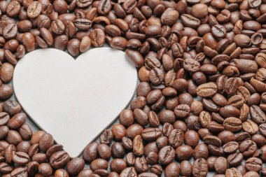 Kahve çekirdekleri arkaplan olarak kavrulmuş ve kalp olarak metne ayrılmış..