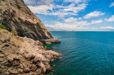 Deniz manzarası, Top view, muhteşem bir arka plan. Suyun rengi ve çok güzel bir şekilde parlak. Kayalık dağları ve güneşli bir günde Kırım 'ın berrak sularıyla dolu gök mavisi bir sahil.