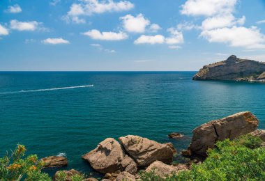 Deniz manzarası, Top view, muhteşem bir arka plan. Suyun rengi ve çok güzel bir şekilde parlak. Kayalık dağları ve güneşli bir günde Kırım 'ın berrak sularıyla dolu gök mavisi bir sahil.
