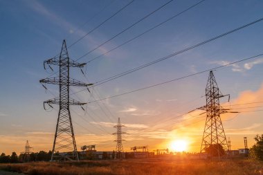 Siluet Yüksek voltajlı elektrik kulesi gün batımı saatinde ve gökyüzü günbatımı arkaplanında