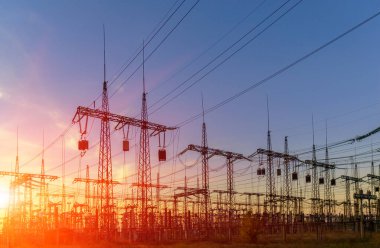 Gün batımında yüksek voltajlı elektrik hatları. Elektrik dağıtım istasyonu