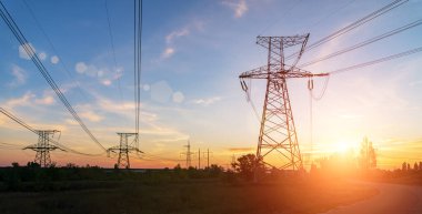 Gün batımında yüksek voltajlı elektrik hatları. Elektrik dağıtım istasyonu