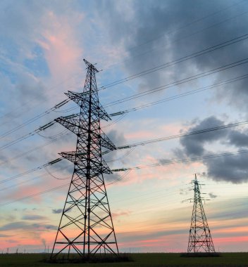 Elektrik hatları ve trafolar olan elektrik santralini gün batımında dağıtın.