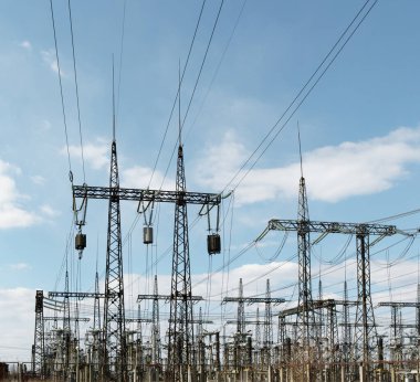 Kentsel alanda yüksek elektrik direkleri var. Enerji arzı, enerji dağılımı, enerji iletimi, enerji iletimi, yüksek voltaj arzı konsepti fotoğrafı.