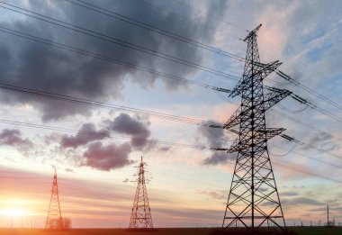 Elektrik hatları ve trafolar olan elektrik santralini gün batımında dağıtın.