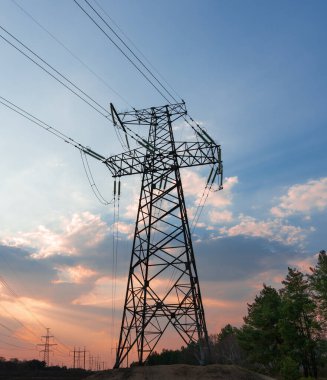 Siluet Yüksek voltajlı elektrik kulesi gün batımı saatinde ve gökyüzü günbatımı arkaplanında.