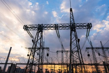 Siluet Yüksek voltajlı elektrik kulesi gün batımı saatinde ve gökyüzü günbatımı arkaplanında.