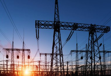 Siluet Yüksek voltajlı elektrik kulesi gün batımı saatinde ve gökyüzü günbatımı arkaplanında.