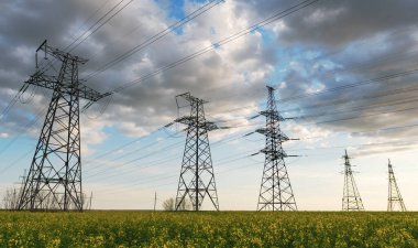 Elektrik hatları ve yüksek gerilim hatları yaz günü yağlı tohumlarla yapılan tecavüzün arka planına karşı. Yeşil enerji. Tarımsal alanlar yoluyla elektrik aktarımı.