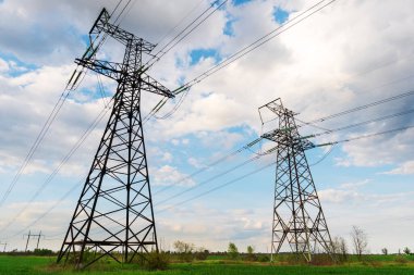 Yeşil alandan geçen yüksek voltajlı elektrik hatları. Tarımsal alanlar yoluyla elektrik aktarımı.