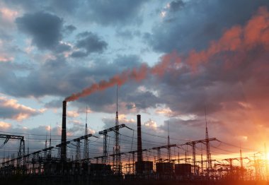 Elektrik hatları ve trafolar olan elektrik santralini gün batımında dağıtın.
