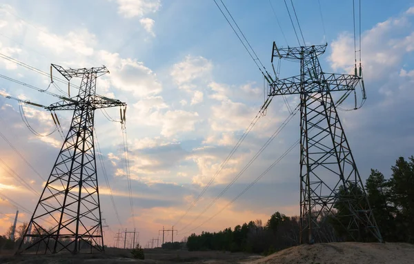 distribution electric substation with power lines and transformers, at sunset.