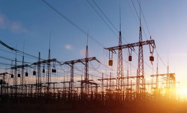 Siluet Yüksek voltajlı elektrik kulesi gün batımı saatinde ve gökyüzü günbatımı arkaplanında.