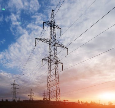 Elektrik direkleri ve gün batımında güç hatları