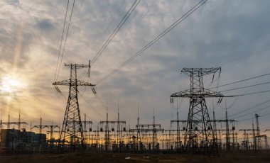Elektrik hatları ve trafolar olan elektrik santralini gün batımında dağıtın.