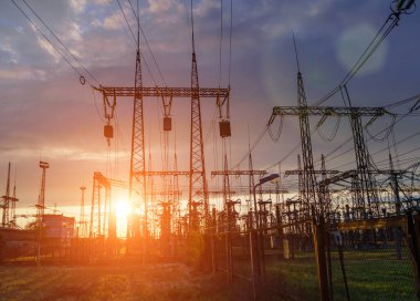 Elektrik hatları ve trafolar olan elektrik santralini gün batımında dağıtın.