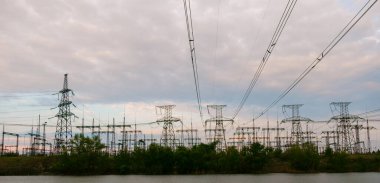 Yüksek voltajlı elektrik hatları. Elektrik dağıtım istasyonu. Yüksek voltajlı elektrik iletim kulesi. Güç hatları ve trafoları olan dağıtım elektrik santrali.