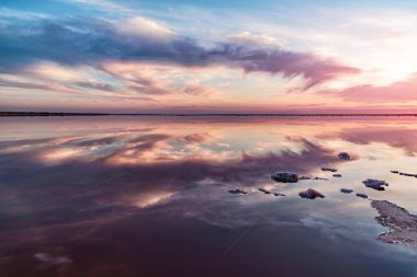 Pembe tuz gölünde gün batımı, pembe tuz çıkarmak için eski bir maden. Tuzla kaplanmış tahta çiviler..