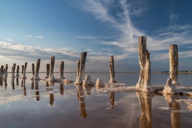 Pembe tuz gölünde gün batımı, pembe tuz çıkarmak için eski bir maden. Tuzla kaplanmış tahta çiviler.