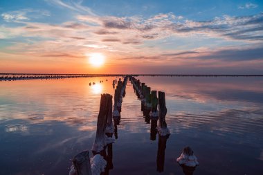 Tuz gölünde gün batımı. Tuz, tuz ve ahşap kazıklar. Tuz özü..
