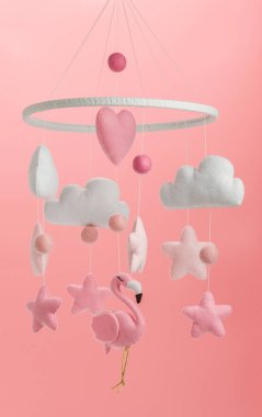 Çocuklar için yapılmış renkli ve çevre dostu bir cep telefonu. Flamingo oyuncakları, bulutlar, yıldızlar ve balonlardan oluşur. Pembe arkaplanda el yapımı.