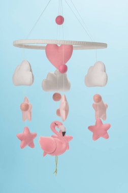 Çocuklar için yapılmış renkli ve çevre dostu bir cep telefonu. Flamingo oyuncakları, bulutlar, yıldızlar ve balonlardan oluşur. Mavi arkaplanda el yapımı.