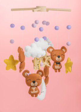 Çocuklar için yapılmış renkli ve çevre dostu bir cep telefonu. Ayılar, yıldızlar, ay, bulutlar ve balonlardan oluşur. Pembe arkaplanda el yapımı.