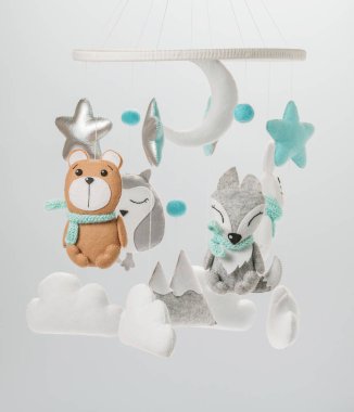 Çocuklar için yapılmış renkli ve çevre dostu bir cep telefonu. Ayı, tilki, baykuş, tavşan, dağ, yıldızlar, bulutlar ve balonlardan oluşur. Gri arkaplanda el yapımı.