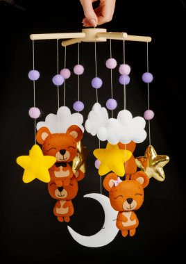 Çocuklar için yapılmış renkli ve çevre dostu bir cep telefonu. Ayılar, yıldızlar, ay, bulutlar ve balonlardan oluşur. Siyah arkaplanda el yapımı.