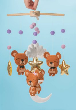 Çocuklar için yapılmış renkli ve çevre dostu bir cep telefonu. Ayılar, yıldızlar, ay, bulutlar ve balonlardan oluşur. Mavi arkaplanda el yapımı.