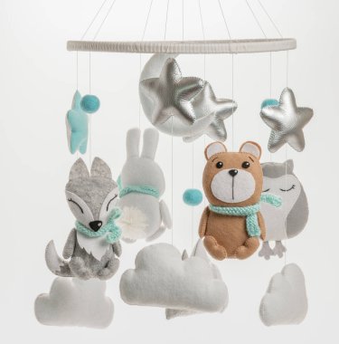 Çocuklar için yapılmış renkli ve çevre dostu bir cep telefonu. Ayı, tilki, baykuş, tavşan, dağ, yıldızlar, bulutlar ve balonlardan oluşur. Gri arkaplanda el yapımı.