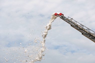 Mavi gökyüzünde köpükle söndürülen ekipman yangını endüstriyel tesislerdeki yangınları söndürüyor.