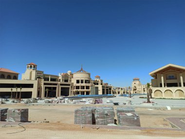 Tatil köyünün inşaatı devam ediyor. Önplanda inşaat malzemeleri olan bitmemiş bir otel..