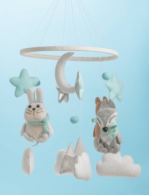 Çocuklar için yapılmış renkli ve çevre dostu bir cep telefonu. Ayı, tilki, baykuş, tavşan, dağ, yıldızlar, bulutlar ve balonlardan oluşur. Mavi arkaplanda el yapımı.