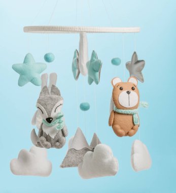 Çocuklar için yapılmış renkli ve çevre dostu bir cep telefonu. Ayı, tilki, baykuş, tavşan, dağ, yıldızlar, bulutlar ve balonlardan oluşur. Mavi arkaplanda el yapımı.