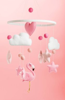 Çocuklar için yapılmış renkli ve çevre dostu bir cep telefonu. Flamingo oyuncakları, bulutlar, yıldızlar ve balonlardan oluşur. Pembe arkaplanda el yapımı.