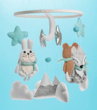 Çocuklar için yapılmış renkli ve çevre dostu bir cep telefonu. Ayı, tilki, baykuş, tavşan, dağ, yıldızlar, bulutlar ve balonlardan oluşur. Mavi arkaplanda el yapımı.