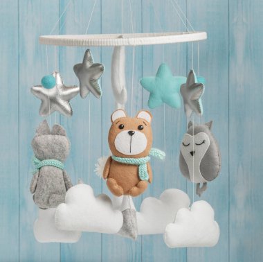 Çocuklar için yapılmış renkli ve çevre dostu bir cep telefonu. Ayı, tilki, baykuş, tavşan, dağ, yıldızlar, bulutlar ve balonlardan oluşur. Ahşaptan yapılmış mavi arka planda el yapımı..