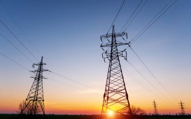 Günbatımında yüksek voltajlı elektrik hatları. Elektrik dağıtım istasyonu. yüksek voltajlı elektrik iletim kulesi