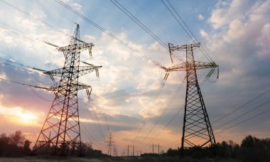 Gün batımında ya da gün doğumunda yüksek voltajlı elektrik hatları. Yüksek voltajlı elektrik iletim kulesi.