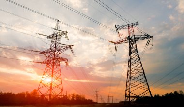 Gün batımında ya da gün doğumunda yüksek voltajlı elektrik hatları. Yüksek voltajlı elektrik iletim kulesi.